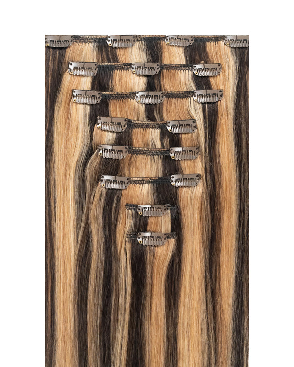 Black hair extensions with caramel highlights adding dimension and warmth